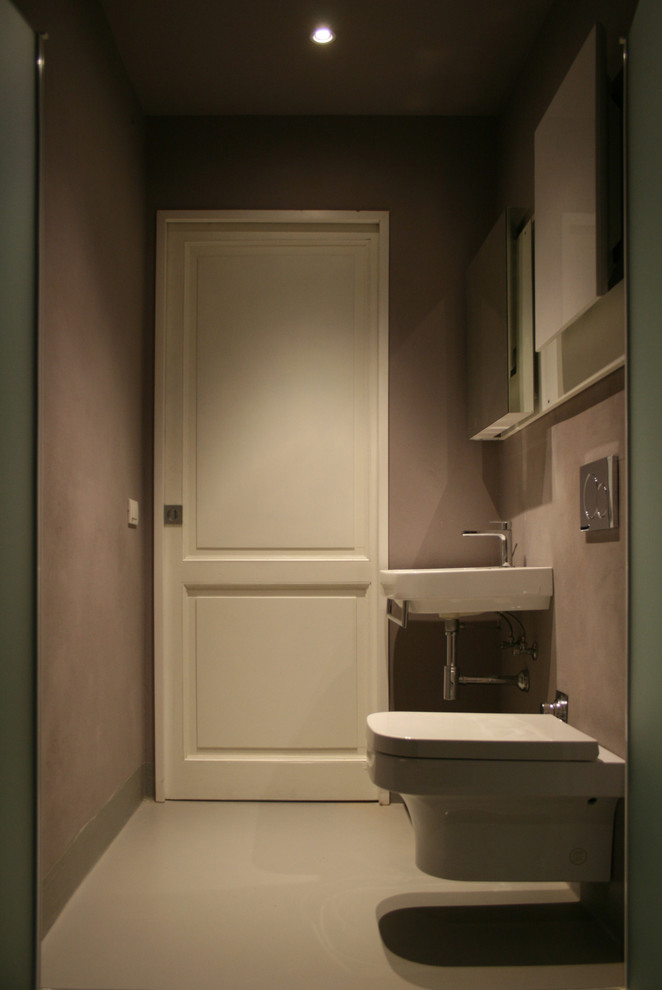 Idee per un piccolo bagno di servizio design con ante lisce, ante bianche, WC monopezzo, pareti marroni, pavimento in cemento, lavabo sospeso e pavimento grigio
