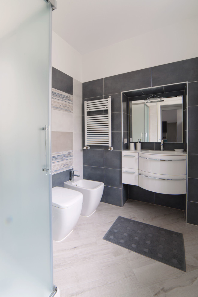Exemple d'un petit WC et toilettes tendance avec un carrelage bleu, un sol en carrelage de céramique, des carreaux de porcelaine, un mur bleu, des portes de placard blanches et un lavabo intégré.
