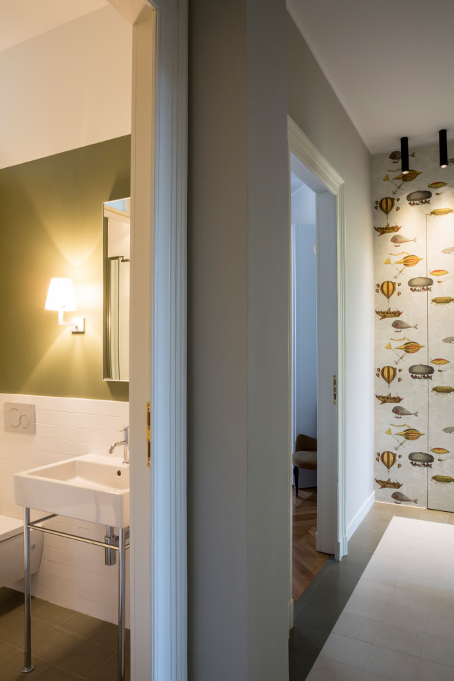 Kleine Moderne Gästetoilette mit Wandtoilette, weißen Fliesen, Keramikfliesen, grüner Wandfarbe, Zementfliesen für Boden, Waschtischkonsole und grünem Boden in Turin