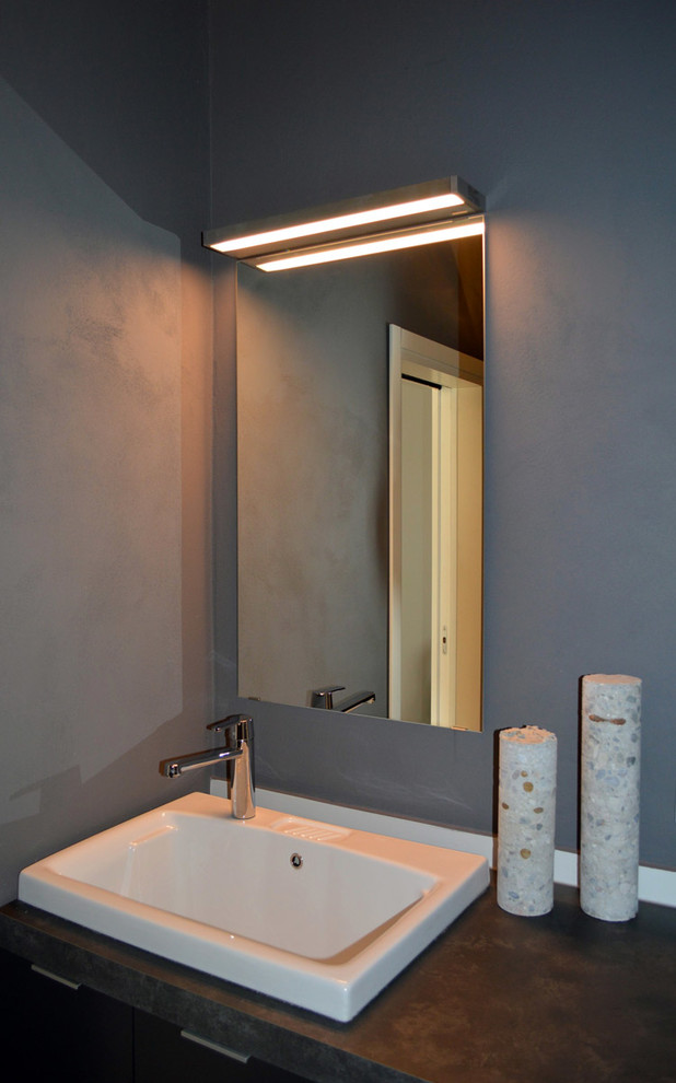 Inspiration for a small industrial cloakroom in Venice with flat-panel cabinets, grey cabinets, grey walls, porcelain flooring, a built-in sink, laminate worktops and brown floors.