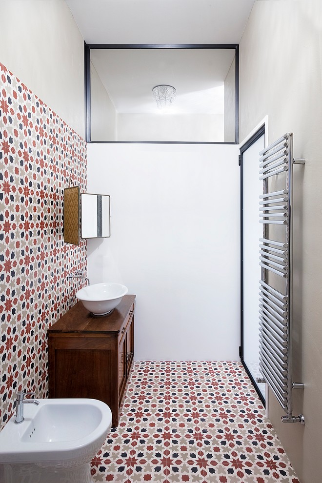 Powder room - small industrial multicolored tile and ceramic tile ceramic tile and multicolored floor powder room idea in Other with furniture-like cabinets, dark wood cabinets, a bidet, white walls, a vessel sink and wood countertops
