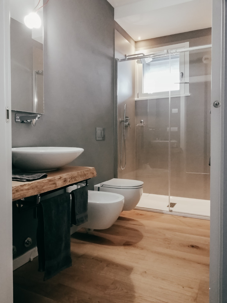 Esempio di un bagno di servizio design di medie dimensioni con pareti grigie e parquet chiaro