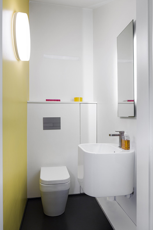 Kleine Moderne Gästetoilette mit offenen Schränken, Toilette mit Aufsatzspülkasten, gelber Wandfarbe und Wandwaschbecken in Mailand