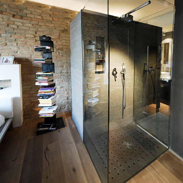 Idee per una stanza da bagno contemporanea con piastrelle di pietra calcarea e pavimento in legno verniciato