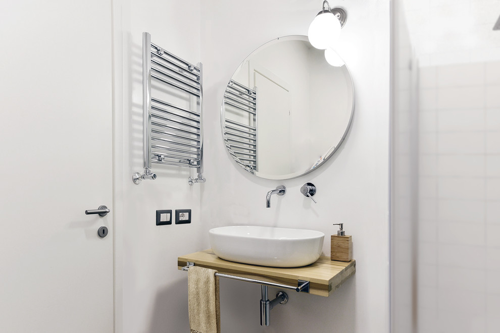 Ispirazione per un piccolo bagno di servizio moderno con WC sospeso, pareti bianche, pavimento in gres porcellanato, lavabo a bacinella, top in legno e pavimento marrone