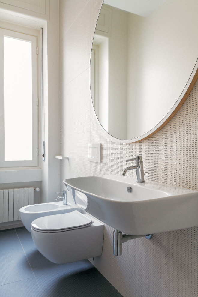 Foto på ett funkis toalett, med en vägghängd toalettstol, klinkergolv i porslin och turkost golv