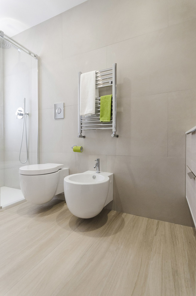 Inspiration för små moderna toaletter, med släta luckor, skåp i ljust trä, en toalettstol med separat cisternkåpa, grå kakel, porslinskakel, grå väggar, klinkergolv i porslin, ett integrerad handfat, bänkskiva i kvarts och grått golv