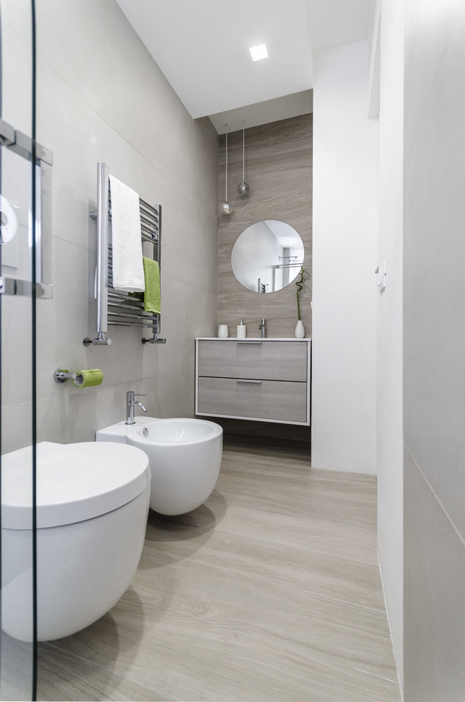 Photo of a small contemporary cloakroom in Rome with flat-panel cabinets, light wood cabinets, a two-piece toilet, grey tiles, porcelain tiles, grey walls, porcelain flooring, an integrated sink, engineered stone worktops and grey floors.