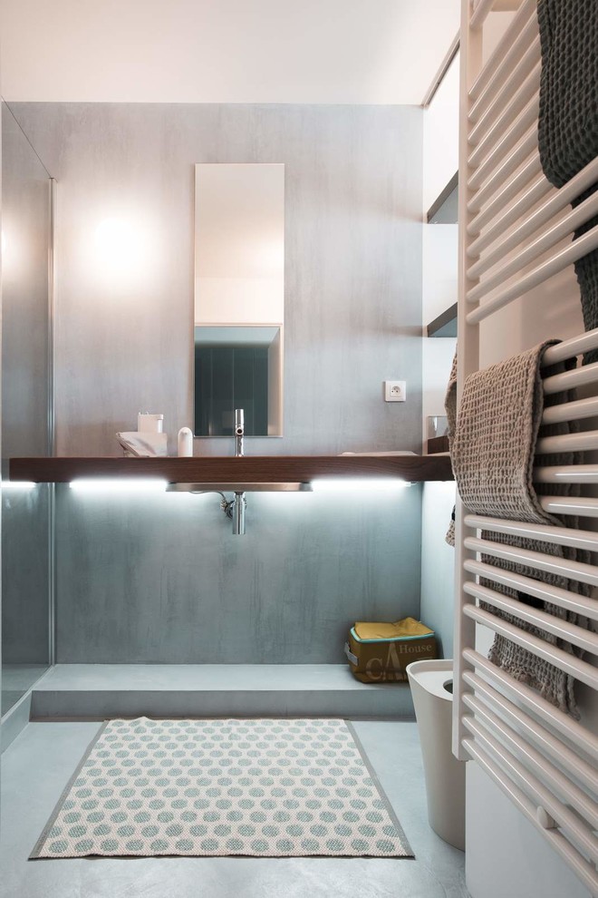 Inredning av ett modernt toalett, med grå väggar, klinkergolv i porslin och ett integrerad handfat
