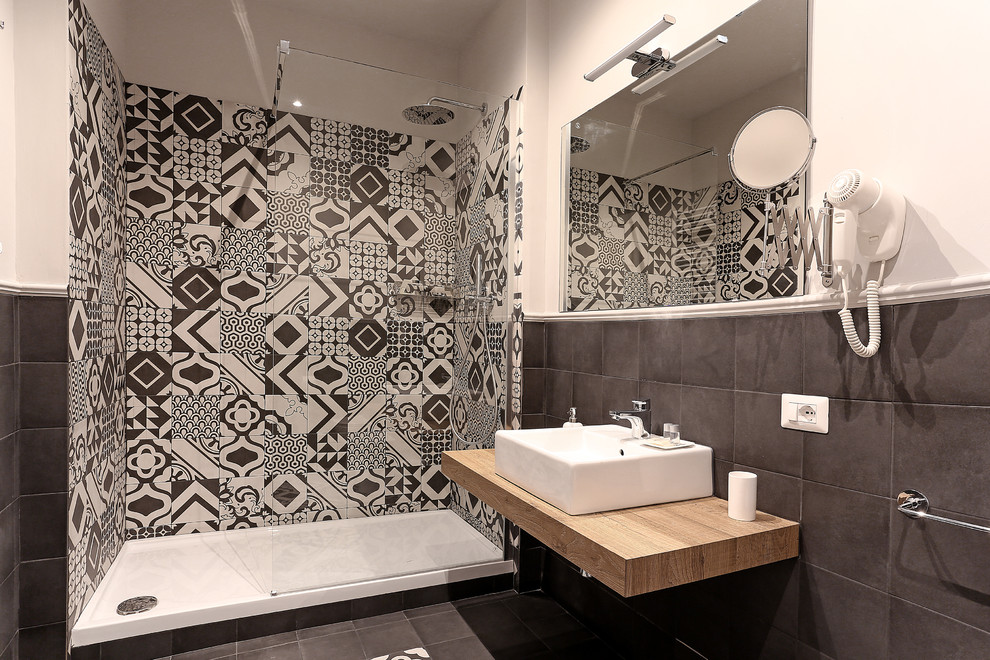 Example of a mid-sized classic porcelain tile and black floor powder room design in Rome with light wood cabinets, black walls and laminate countertops