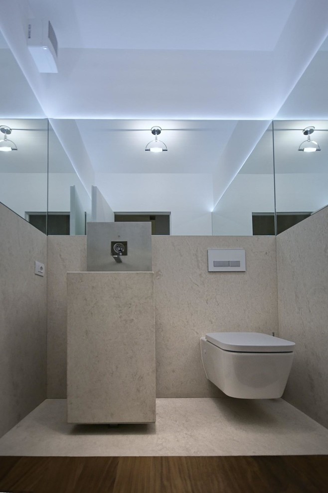 Inspiration for a small contemporary cloakroom in Milan with a wall mounted toilet, multi-coloured walls, dark hardwood flooring, an integrated sink and stainless steel worktops.