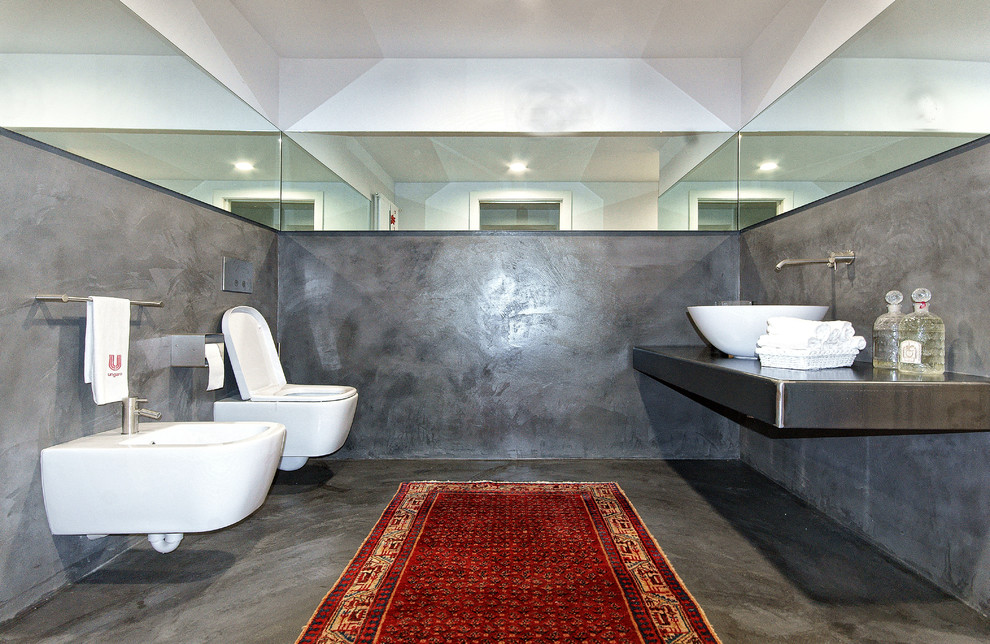 Esempio di una stanza da bagno minimal di medie dimensioni con WC sospeso, lavabo a bacinella, top in acciaio inossidabile e piastrelle grigie
