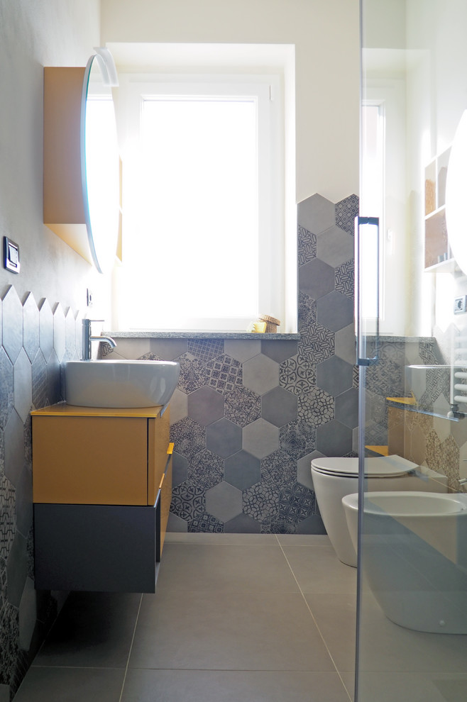 Design ideas for a small modern cloakroom in Turin with flat-panel cabinets, yellow cabinets, a bidet, grey tiles, porcelain tiles, white walls, porcelain flooring, a vessel sink, grey floors and yellow worktops.