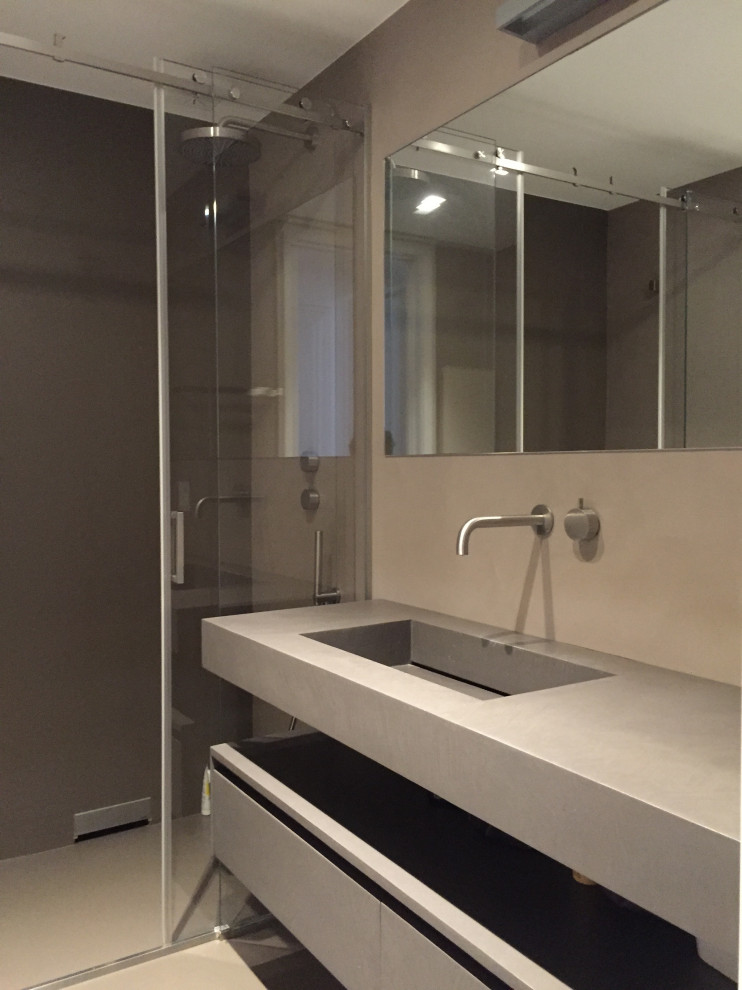 This is an example of a medium sized contemporary cloakroom in Bari with grey cabinets, a two-piece toilet, grey walls, a built-in sink, concrete worktops, grey floors and a floating vanity unit.