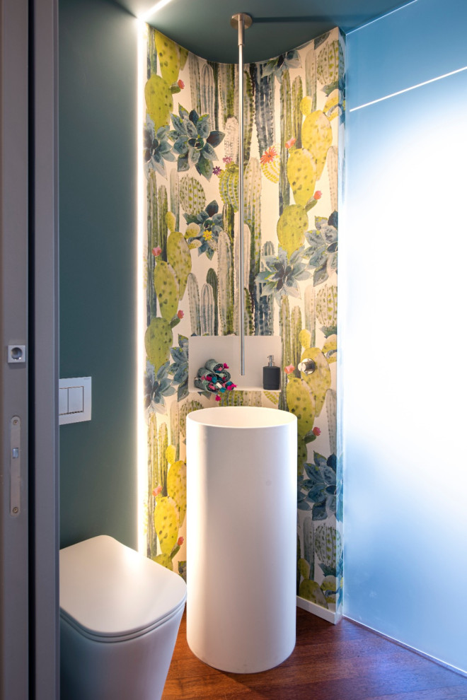 カターニア／パルレモにあるコンテンポラリースタイルのおしゃれなトイレ・洗面所 (マルチカラーの壁、濃色無垢フローリング、ペデスタルシンク、茶色い床、壁紙) の写真