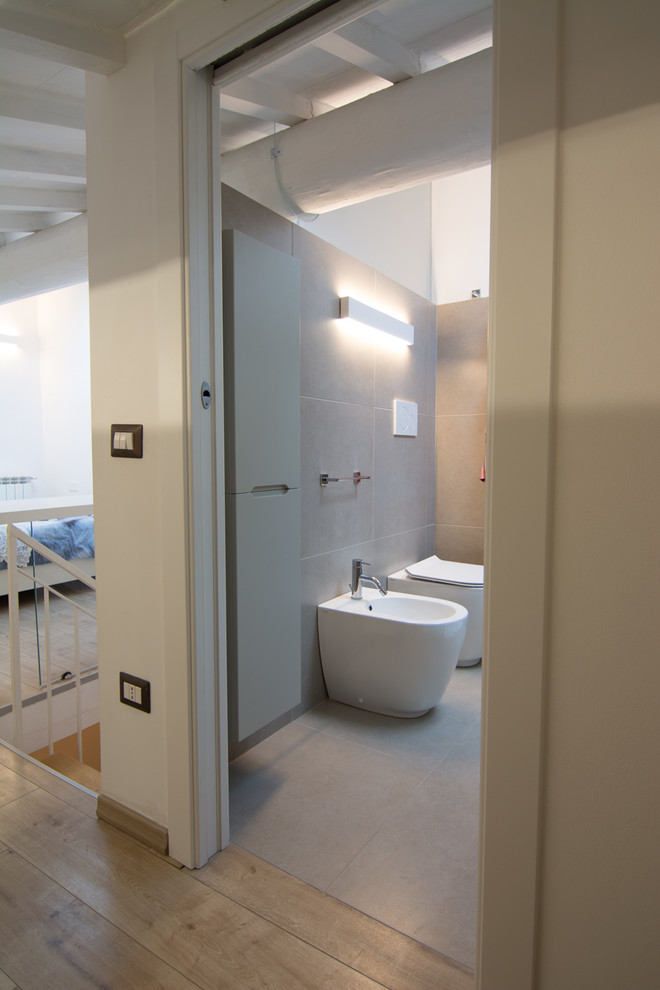Foto på ett stort minimalistiskt toalett, med vita väggar, linoleumgolv och beiget golv