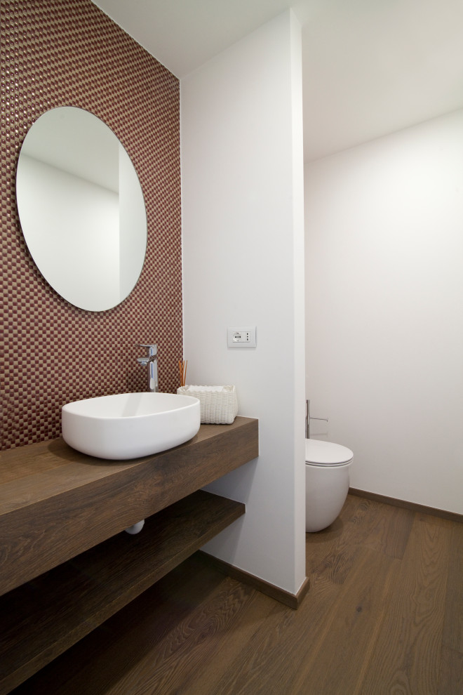 Immagine di un piccolo bagno di servizio minimalista con ante lisce, ante bianche, lavabo a bacinella, top in superficie solida, pavimento marrone, top bianco e mobile bagno sospeso