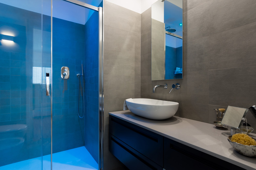 Foto di una stanza da bagno design di medie dimensioni con piastrelle grigie, piastrelle in gres porcellanato, pareti grigie e lavabo a bacinella