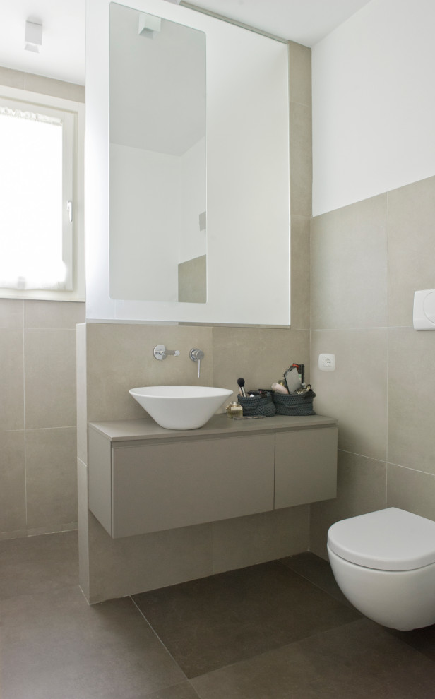 Inspiration for a small modern cloakroom in Milan with flat-panel cabinets, brown cabinets, a wall mounted toilet, brown tiles, porcelain tiles, white walls, porcelain flooring, a vessel sink, solid surface worktops, brown floors and brown worktops.