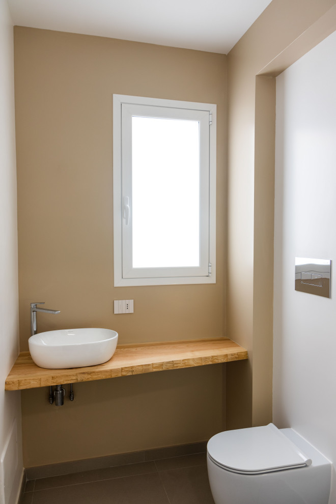 Idées déco pour un petit WC et toilettes moderne en bois clair avec WC séparés, un sol en carrelage de porcelaine, une vasque, un sol gris, meuble-lavabo sur pied et du lambris.