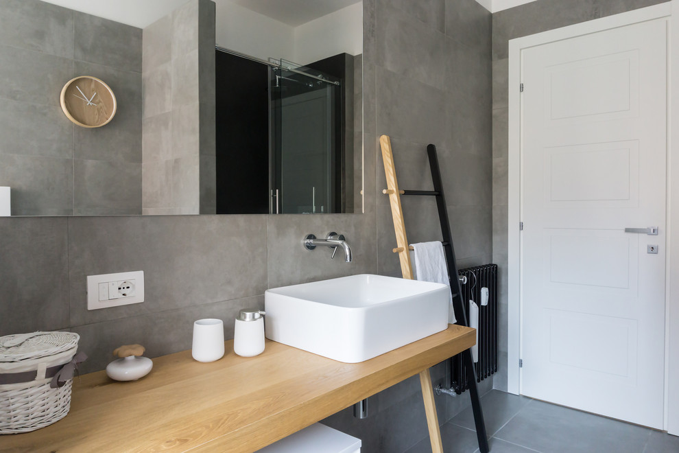Idée de décoration pour un WC et toilettes nordique de taille moyenne avec un mur gris et un sol en carrelage de porcelaine.