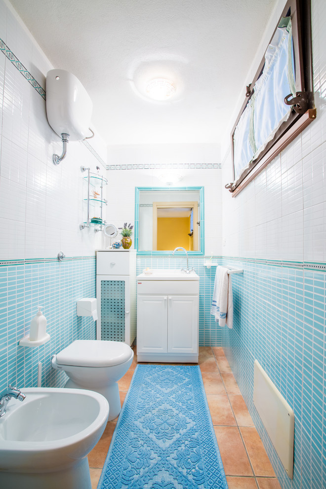Источник вдохновения для домашнего уюта: туалет в морском стиле с плоскими фасадами, белыми фасадами, раздельным унитазом, синей плиткой, керамогранитной плиткой, белыми стенами, полом из керамогранита, монолитной раковиной и коричневым полом