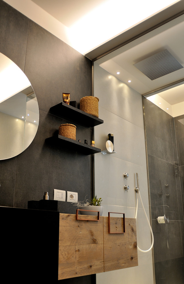 Kleine Moderne Gästetoilette mit flächenbündigen Schrankfronten, schwarzer Wandfarbe und Waschtisch aus Holz in Bologna