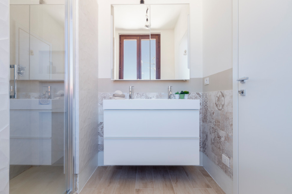 Photo of a small modern cloakroom in Milan with flat-panel cabinets, white cabinets, a two-piece toilet, multi-coloured tiles, porcelain tiles, beige walls, wood-effect flooring, an integrated sink, engineered stone worktops, beige floors, white worktops and a floating vanity unit.