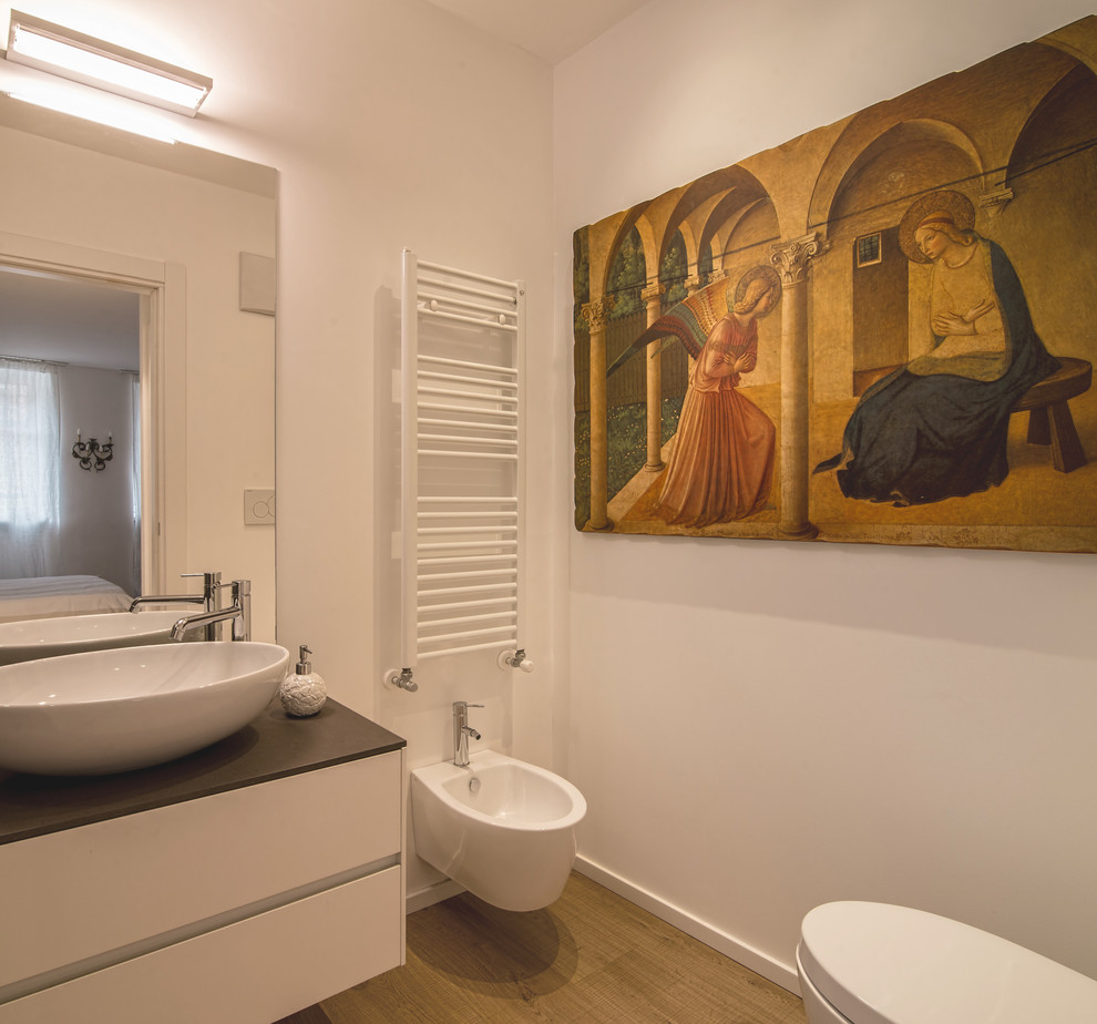 Foto di un bagno di servizio moderno con ante lisce, ante bianche, bidè, pareti bianche, parquet chiaro, top grigio, lavabo a bacinella e pavimento marrone