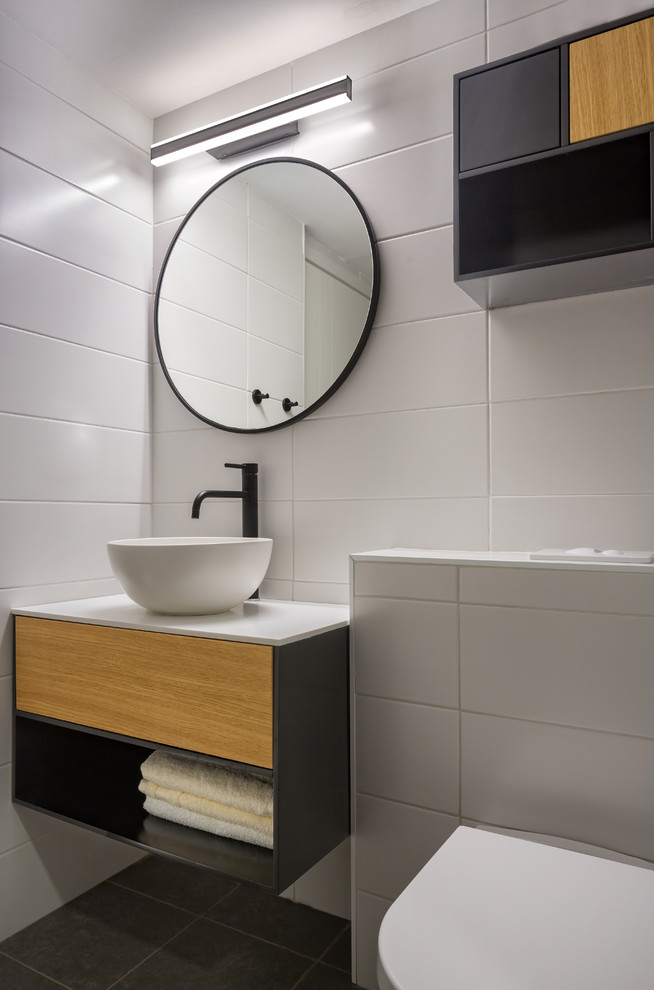 Idee per un piccolo bagno di servizio moderno con ante grigie, WC sospeso, piastrelle bianche, pareti bianche, pavimento grigio, top bianco, ante lisce e lavabo a bacinella