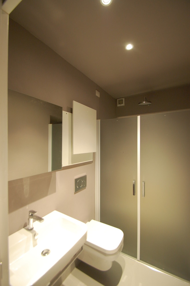 Idee per un piccolo bagno di servizio minimal con ante lisce, ante bianche, WC monopezzo, pareti marroni, pavimento in cemento, lavabo sospeso e pavimento grigio