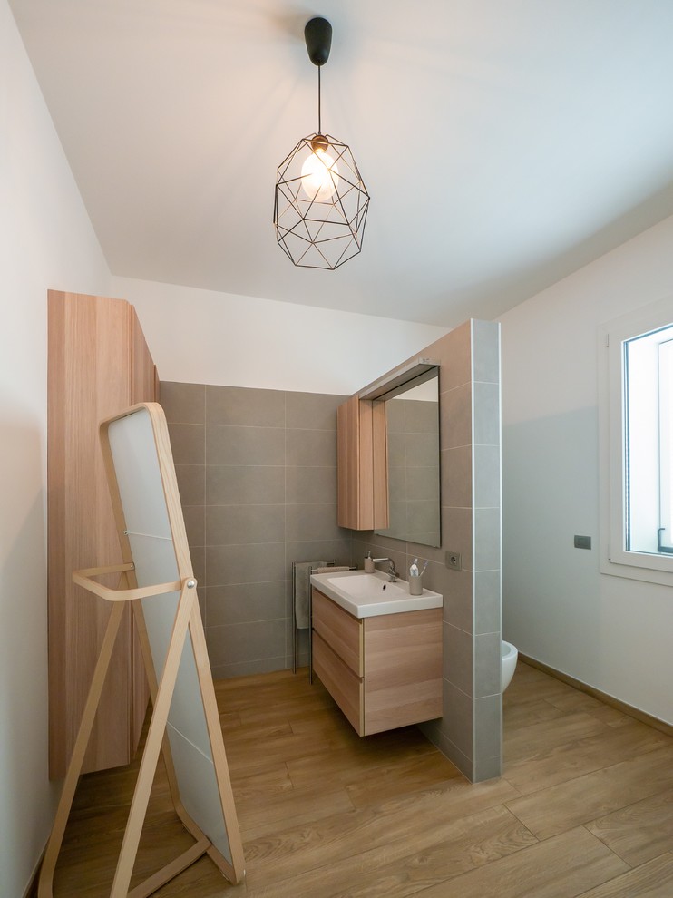 Idées déco pour un grand WC suspendu scandinave en bois clair avec un placard à porte plane, un carrelage gris, des carreaux de porcelaine, un mur blanc, un sol en carrelage de porcelaine, un plan vasque, un plan de toilette en bois, un sol beige et un plan de toilette beige.