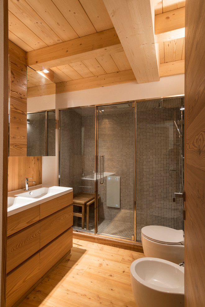 Ispirazione per un bagno di servizio rustico con WC a due pezzi, pavimento in legno massello medio e lavabo integrato