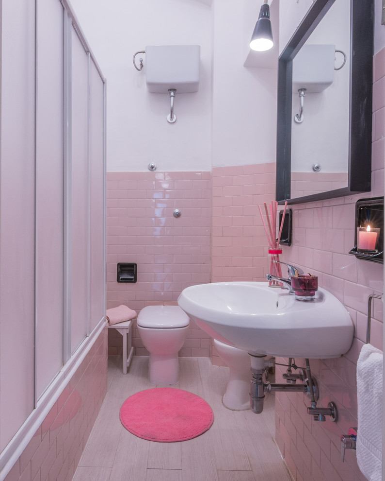 Idée de décoration pour un WC et toilettes tradition avec WC à poser, un carrelage rose, des carreaux en allumettes, un mur rose, un sol en linoléum, un lavabo de ferme et un sol gris.