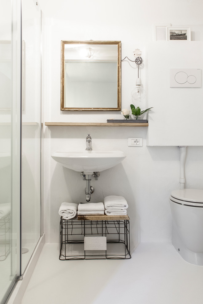 Ispirazione per un bagno di servizio nordico con nessun'anta, WC a due pezzi, pareti bianche, lavabo sospeso e pavimento bianco