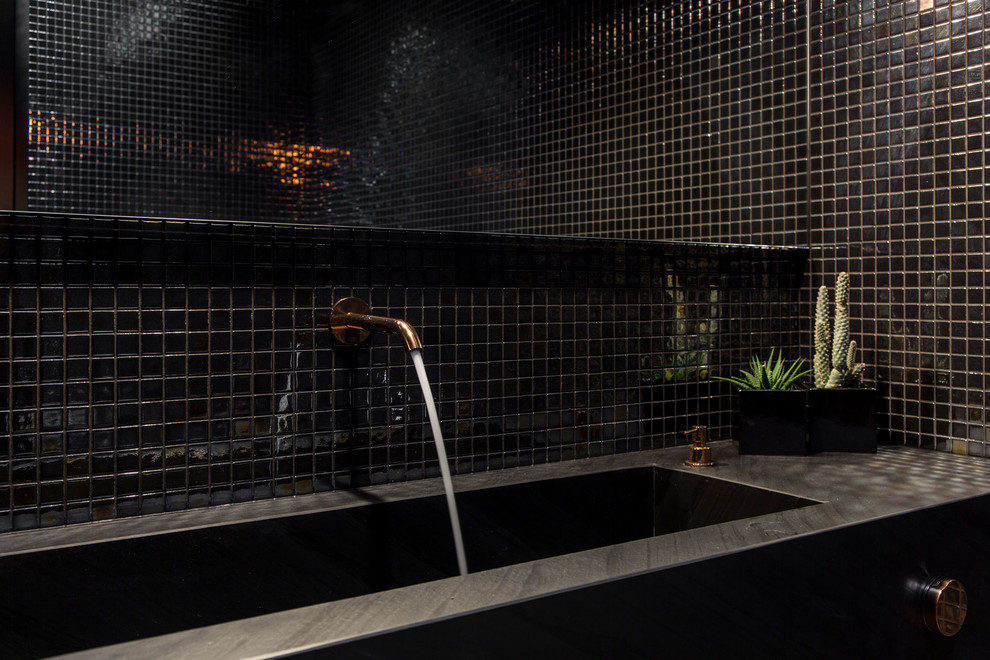 Idee per un bagno di servizio design di medie dimensioni con ante nere, WC sospeso, piastrelle nere, piastrelle a mosaico, pavimento in legno massello medio, lavabo integrato e top in marmo