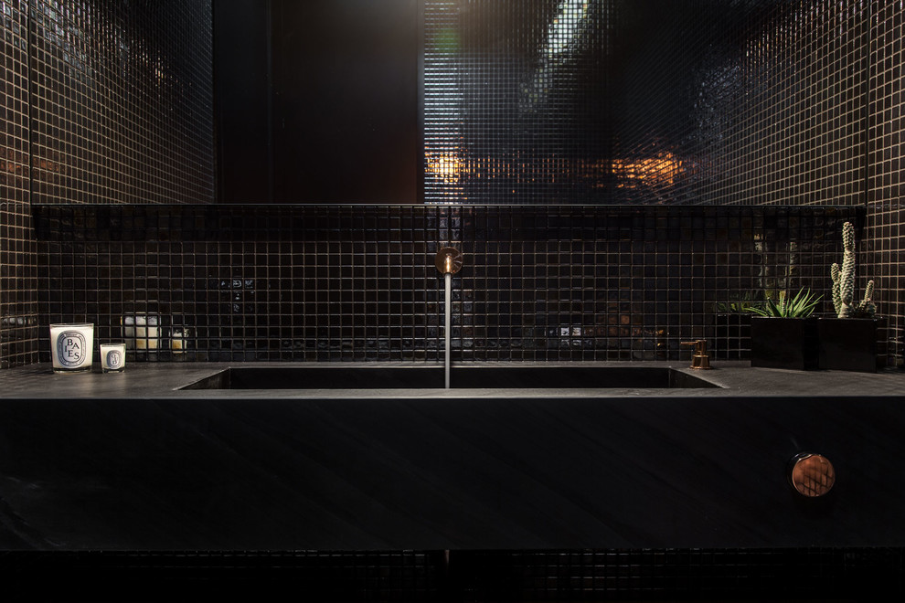 Inspiration för mellanstora moderna toaletter, med svarta skåp, en vägghängd toalettstol, svart kakel, mosaik, mellanmörkt trägolv, ett integrerad handfat och marmorbänkskiva