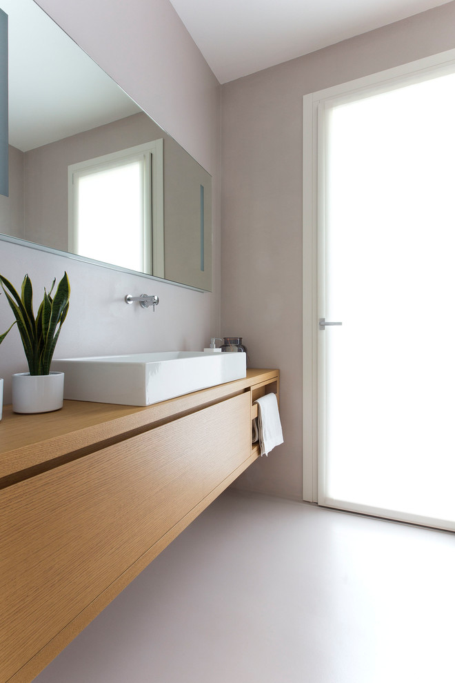 Esempio di un bagno di servizio contemporaneo di medie dimensioni con ante in legno chiaro, WC sospeso, pareti beige, lavabo a bacinella, top in legno, pavimento beige e top marrone