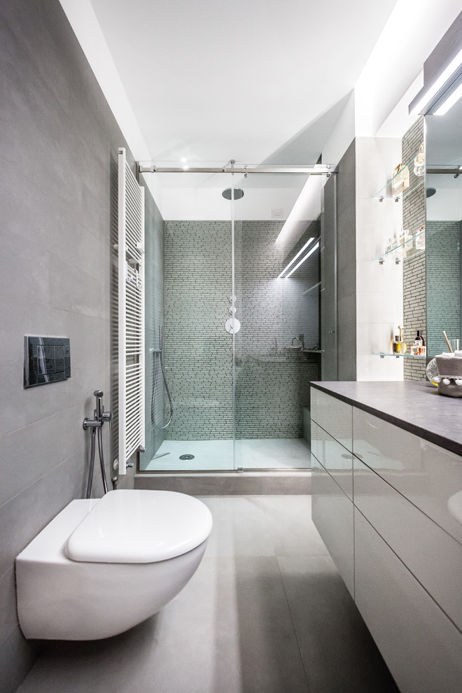 Foto de cuarto de baño actual pequeño con armarios con paneles lisos y baldosas y/o azulejos grises