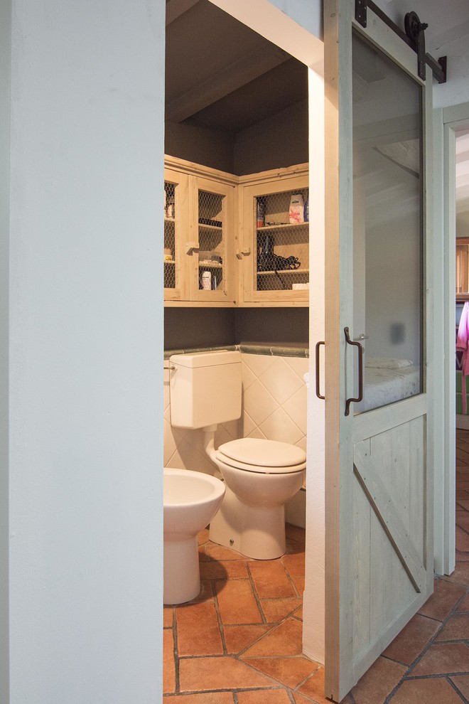 На фото: маленький туалет в стиле лофт с раздельным унитазом, керамической плиткой, полом из терракотовой плитки и раковиной с пьедесталом для на участке и в саду