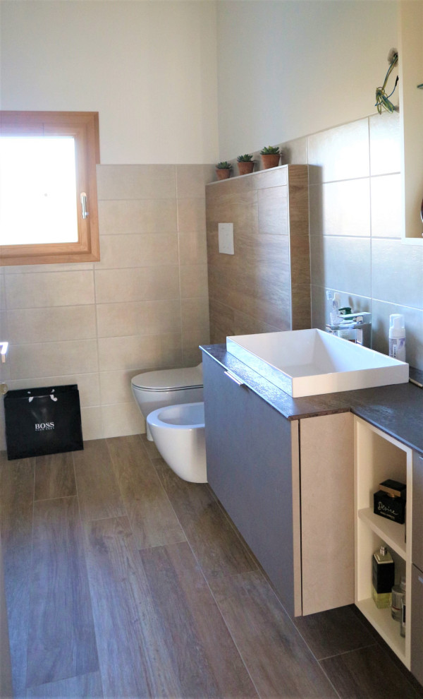 Стильный дизайн: маленький туалет в стиле модернизм с коричневыми фасадами, раздельным унитазом, бежевой плиткой, керамогранитной плиткой, полом из керамогранита, накладной раковиной и бежевым полом для на участке и в саду - последний тренд