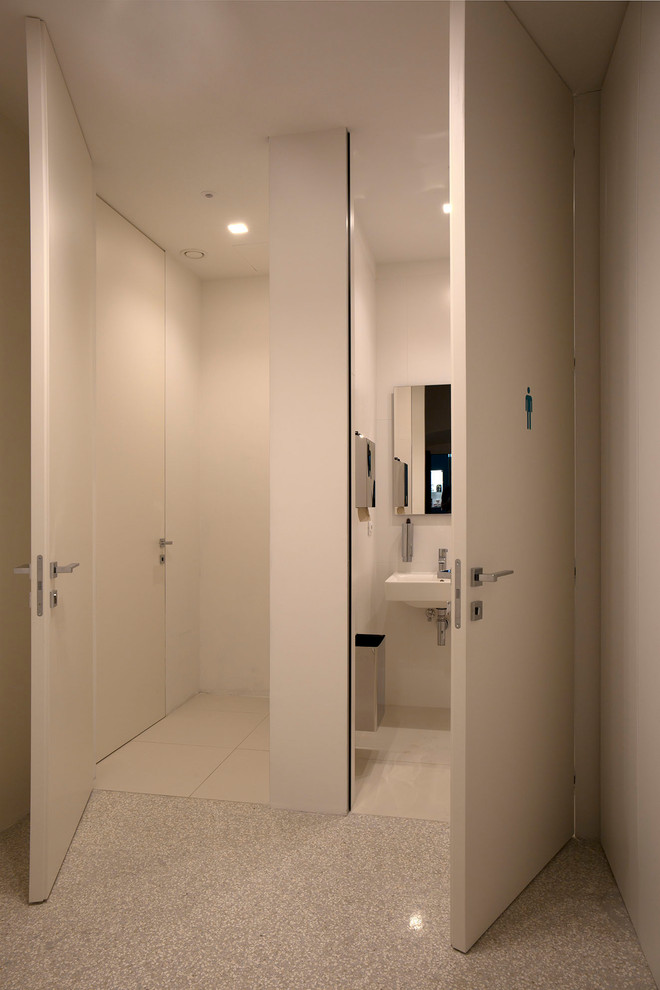 Large contemporary cloakroom in Florence with beaded cabinets, white walls, concrete flooring and grey floors.