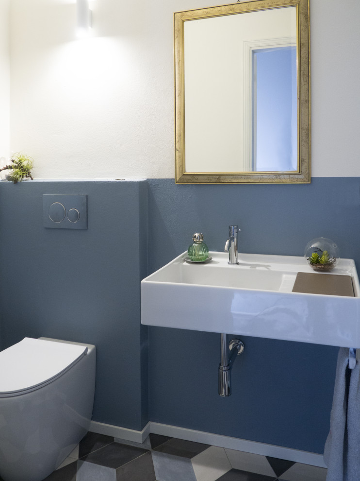 Immagine di un piccolo bagno di servizio design con pareti blu, pavimento in gres porcellanato, lavabo sospeso e pavimento multicolore