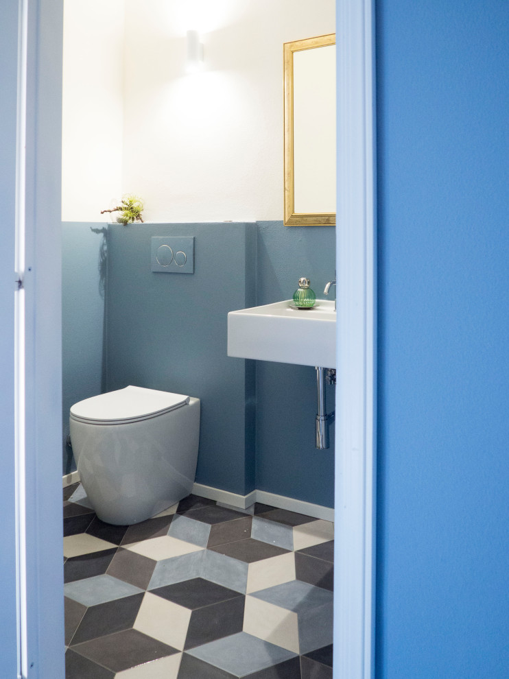 На фото: маленький туалет в современном стиле с синими стенами, полом из керамогранита, подвесной раковиной и разноцветным полом для на участке и в саду