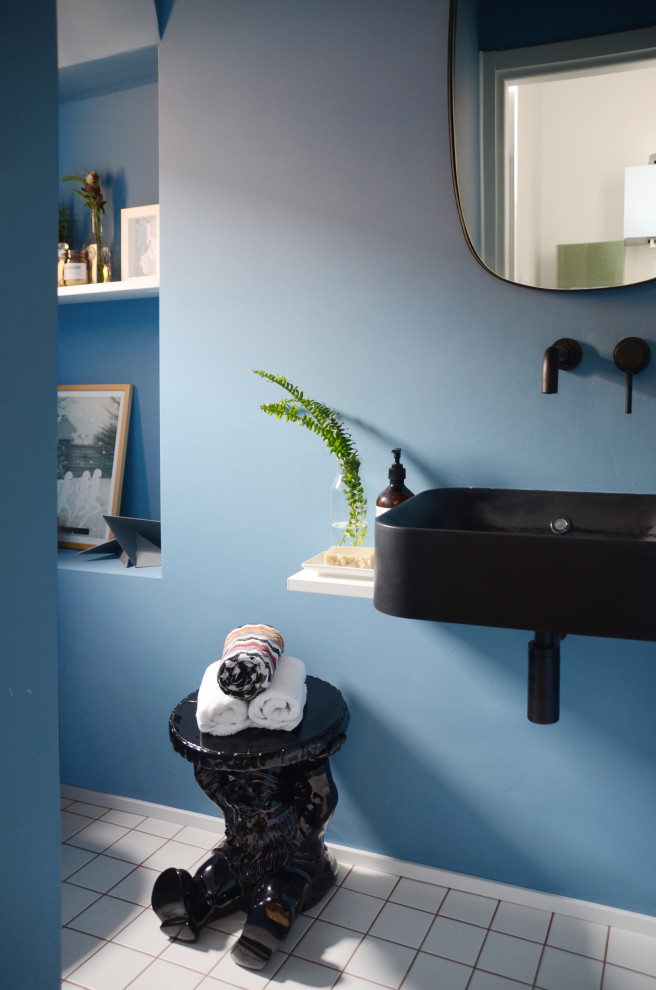 Источник вдохновения для домашнего уюта: маленький туалет в стиле фьюжн с открытыми фасадами, синими фасадами, инсталляцией, синей плиткой, синими стенами, полом из керамической плитки, настольной раковиной, столешницей из дерева, белым полом, черной столешницей и подвесной тумбой для на участке и в саду
