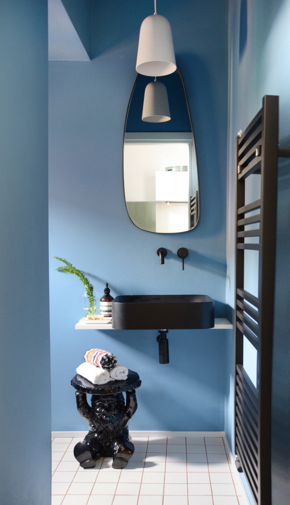 Kleine Moderne Gästetoilette mit blauer Wandfarbe, Keramikboden, Aufsatzwaschbecken, weißem Boden, schwebendem Waschtisch und weißer Waschtischplatte in Mailand