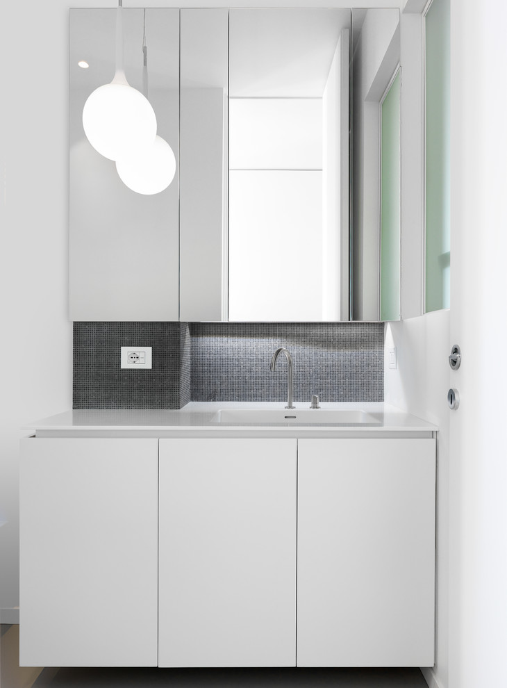 Esempio di un bagno di servizio minimalista di medie dimensioni con ante lisce, ante bianche, WC a due pezzi, piastrelle nere, piastrelle di vetro, pareti nere, pavimento in legno massello medio, lavabo integrato, top in superficie solida e top bianco