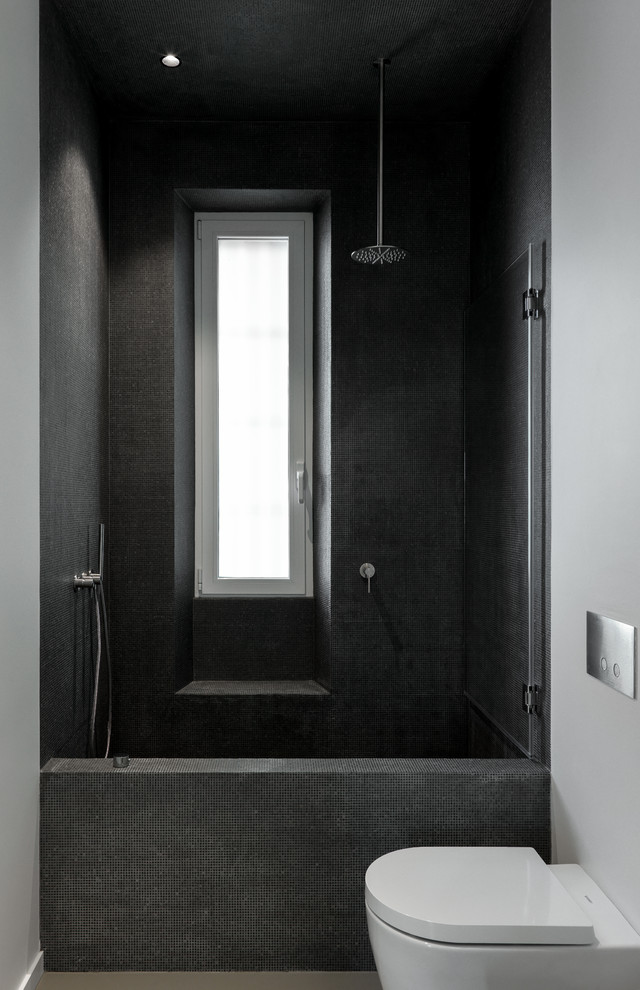 Esempio di un bagno di servizio moderno di medie dimensioni con WC a due pezzi, piastrelle nere, piastrelle di vetro, pareti bianche, pavimento in cemento e pavimento grigio