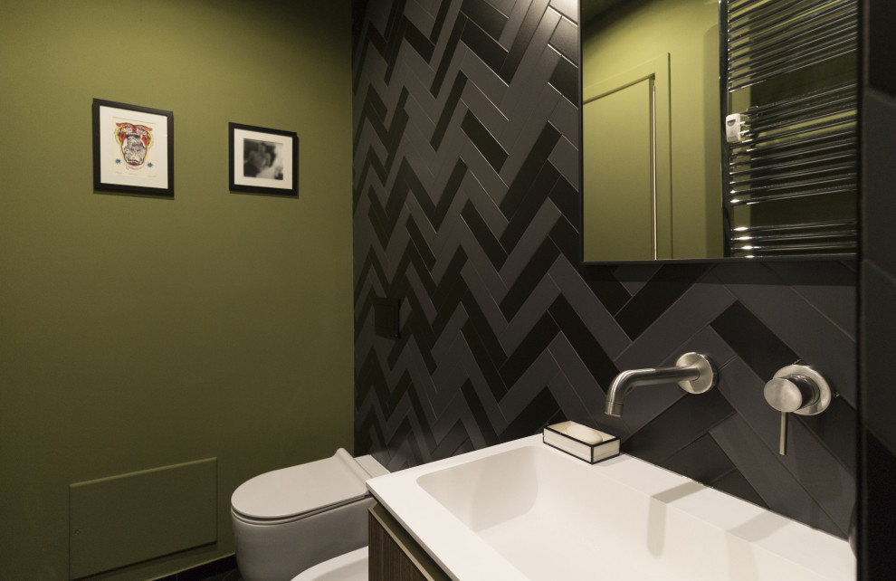 Inredning av ett modernt litet vit vitt toalett, med släta luckor, skåp i mörkt trä, en vägghängd toalettstol, flerfärgad kakel, porslinskakel, gröna väggar, klinkergolv i porslin, ett nedsänkt handfat, bänkskiva i akrylsten och flerfärgat golv