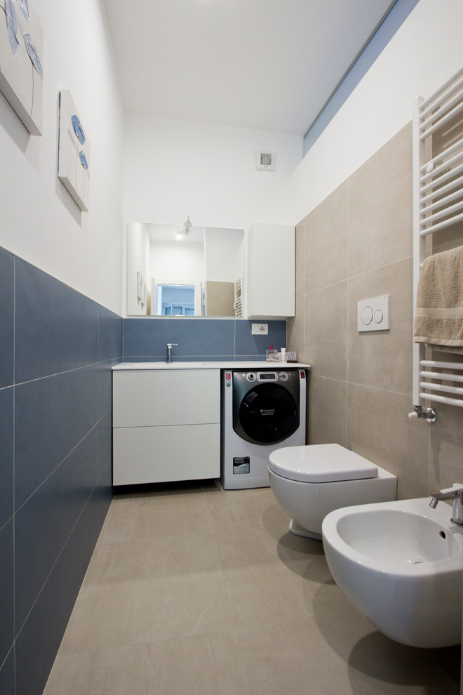 Photo of a medium sized contemporary cloakroom in Milan with blue walls, porcelain flooring, beige floors, flat-panel cabinets, white cabinets, a wall mounted toilet, blue tiles, porcelain tiles, an integrated sink, solid surface worktops and white worktops.